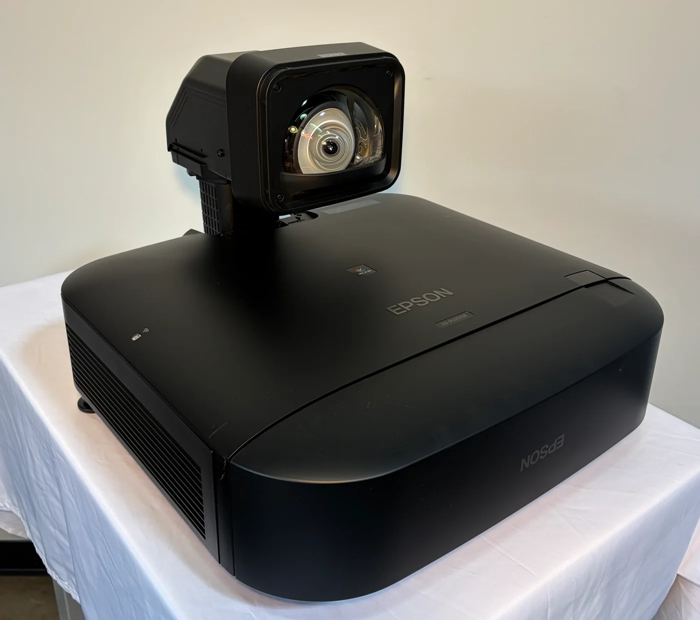Black Epson projector with an ultra-short-throw lens on a workbench.