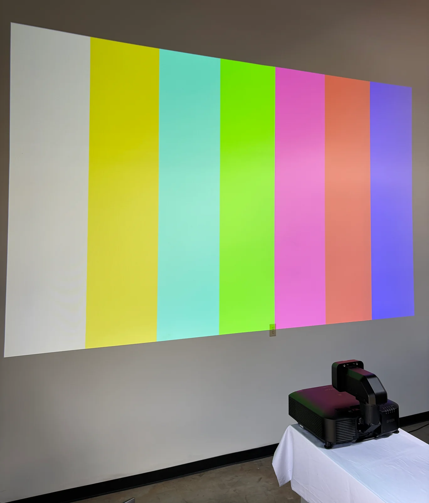 Epson projector on a workbench projecting color bars onto a wall.